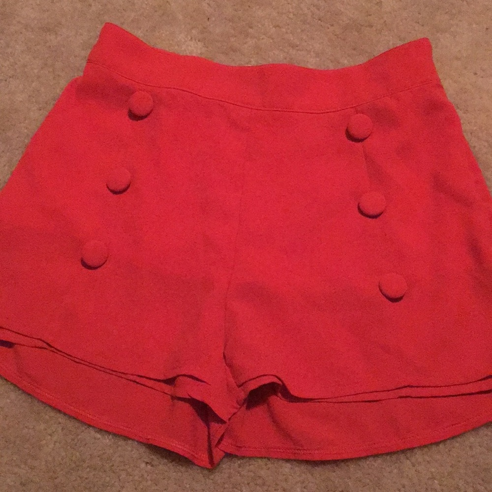 Side zip coral red high waisted shorts.